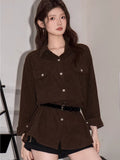 Close-up of a woman wearing a brown corduroy oversized shirt with chest pockets.