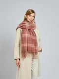 Woman posing with a pink and beige plaid scarf.