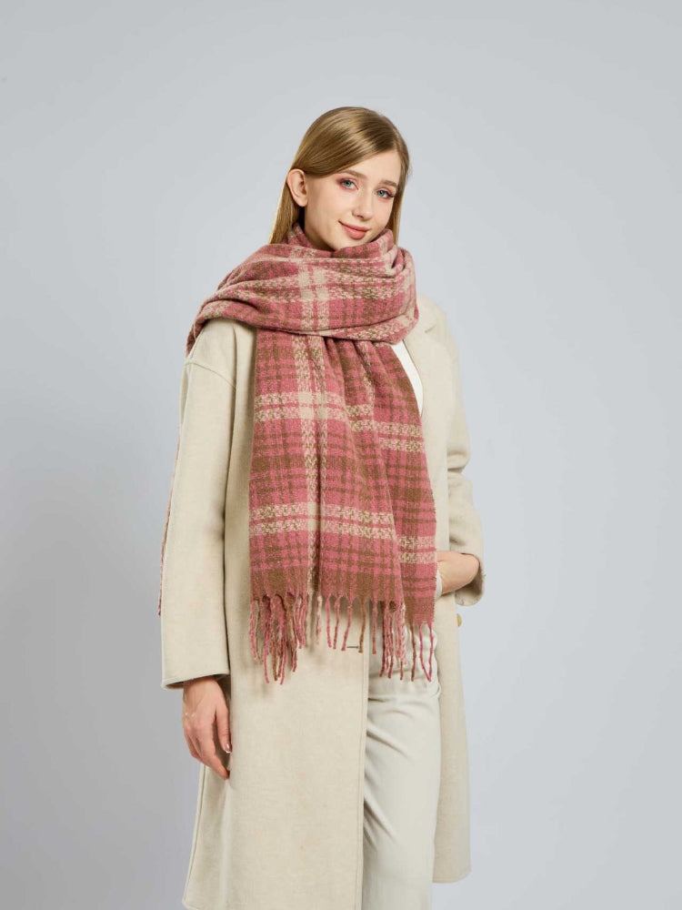 Woman posing with a pink and beige plaid scarf.