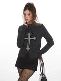 Close-up of a woman wearing a dark grey knit zip-up cardigan with a grey embroidered cross.