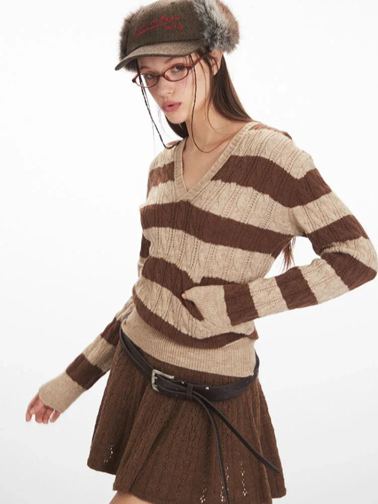Side view of a woman wearing a brown and beige striped knit hooded sweater with a v-neckline and long sleeves, demonstrating the fit.