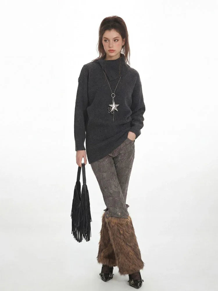 Woman wearing a charcoal grey knit tunic sweater with a high turtleneck and long sleeves.