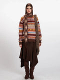 Woman wearing a striped turtleneck sweater with geometric patterns, paired with a brown asymmetrical skirt and boots.