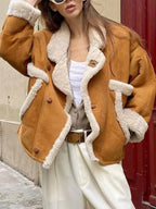 Close-up of the collar and lapels of a faux suede shearling jacket.