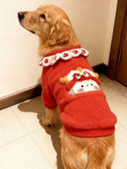 Golden Retriever dog wearing a red fleece dog sweater with a white ruffled collar and embroidered strawberry pattern, facing left