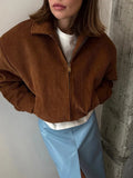 Woman wearing a brown corduroy jacket with her hands in the pockets.