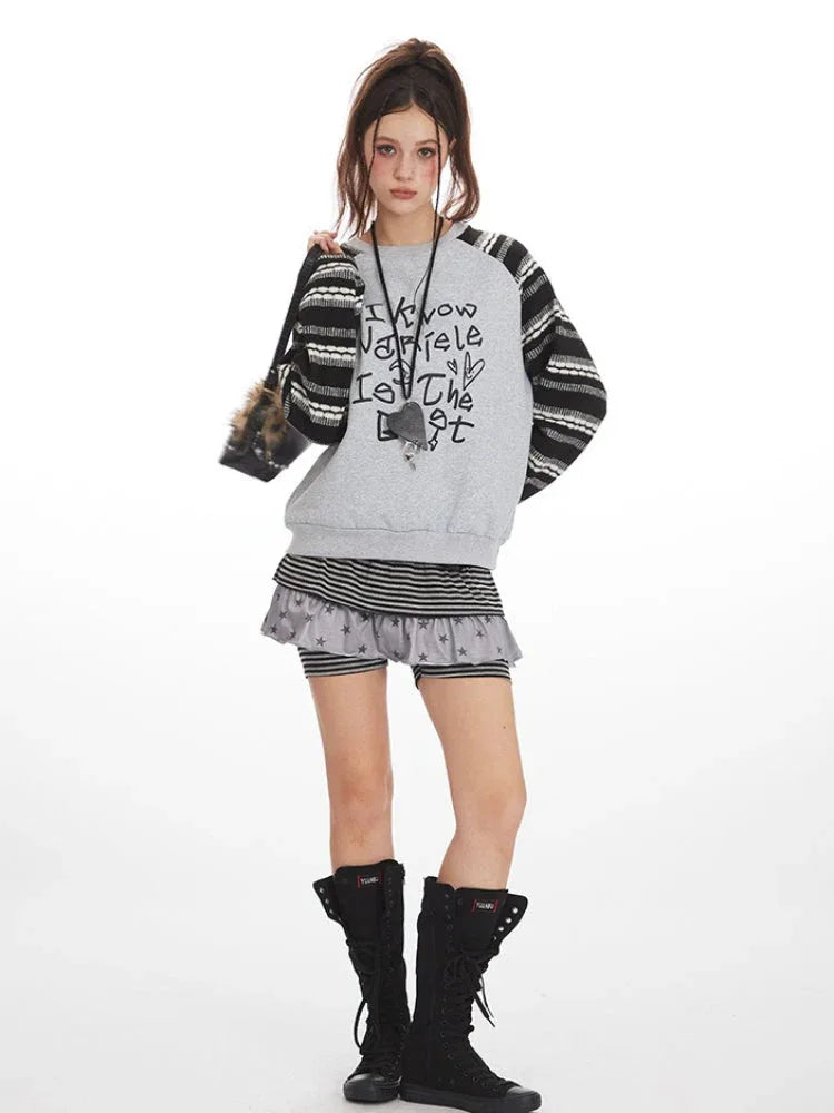 Full body shot of a model in a casual outfit featuring a graphic sweatshirt and shorts.