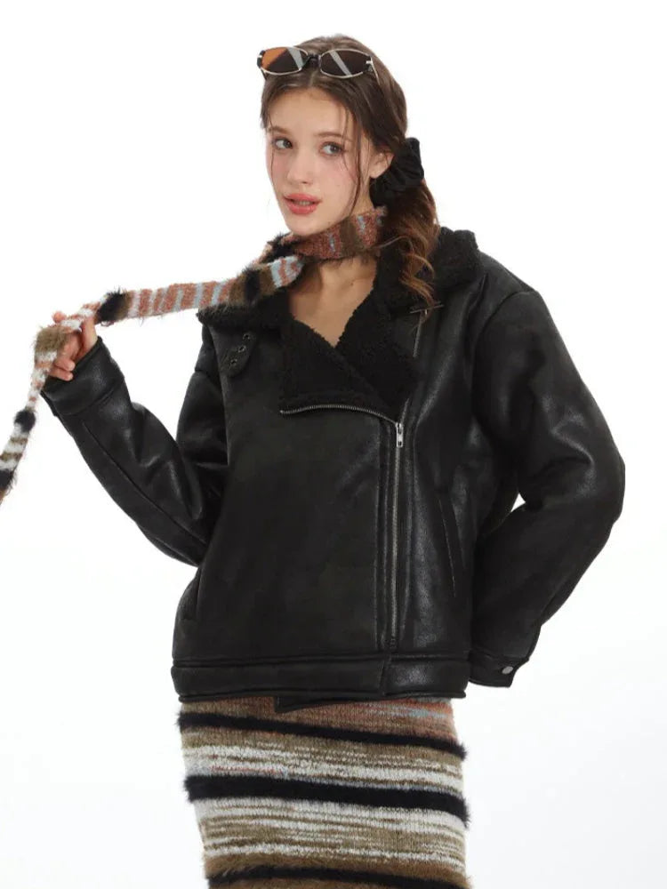 Woman modeling a black faux leather aviator jacket and striped maxi skirt, holding a striped scarf.