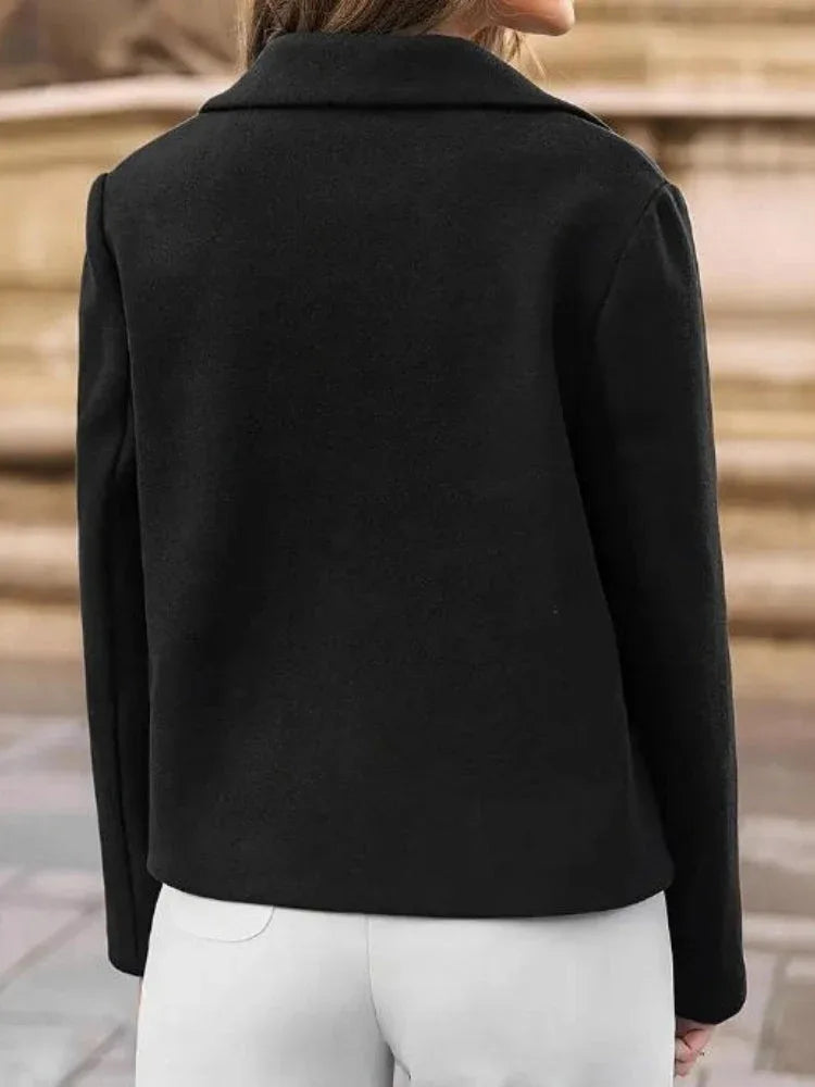 Back view of a black cropped jacket with long sleeves.