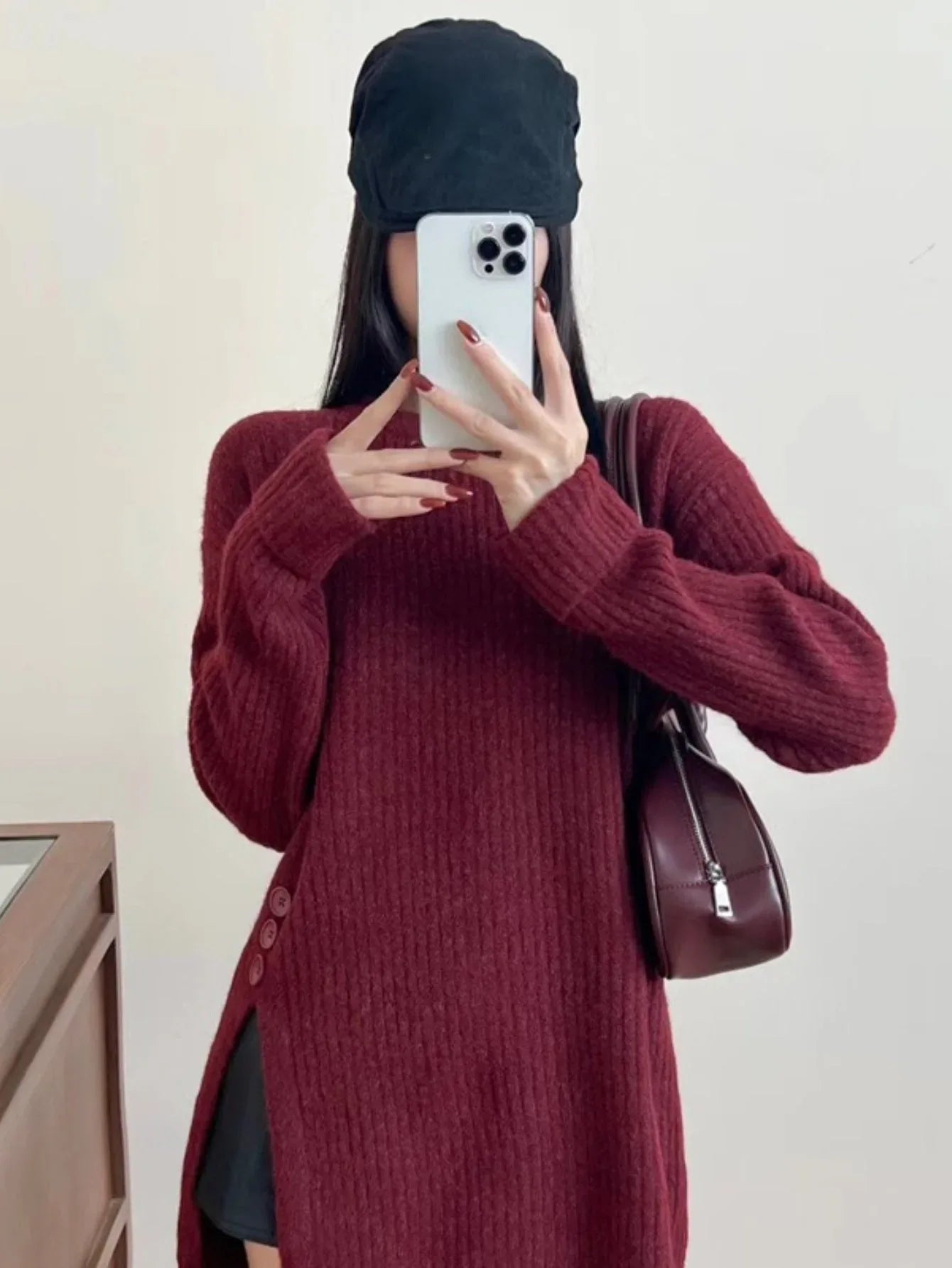Burgundy oversized knit sweater with crew neck and button details on the side.