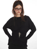 Front view of the model, focusing on the black long-sleeved top and its details.