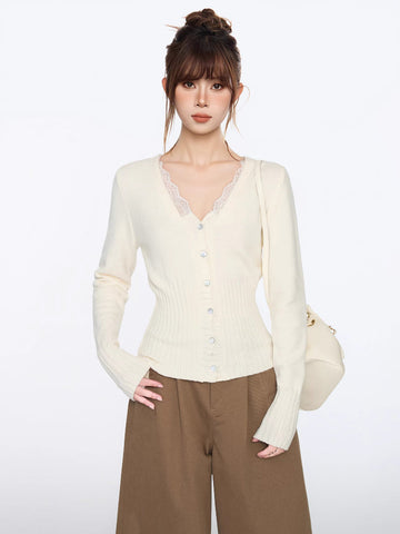 Woman wearing a cream knit cardigan with lace trim and button front, paired with brown wide-leg pants.
