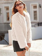 Side profile of a woman in a white faux fur cropped jacket.