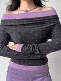 Close-up of a woman in a grey and purple off-the-shoulder top, showing the neckline and print.
