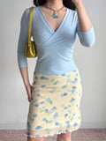 outfit featuring a light blue wrap top and a yellow floral mesh skirt