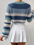 Back view of a woman in a blue, white, and green striped crochet knit cropped sweater with bell sleeves.