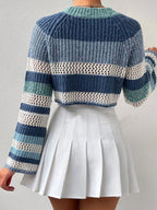 Back view of a woman in a blue, white, and green striped crochet knit cropped sweater with bell sleeves.