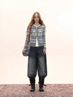 Woman wearing a grey button-down cardigan with a Fair Isle knit pattern, white t-shirt, wide-leg jeans, and a crossbody bag.