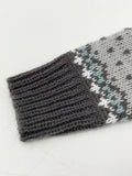 Close-up of the ribbed cuff of a grey knit sweater