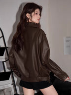 Back view of a woman in a brown faux leather moto jacket.