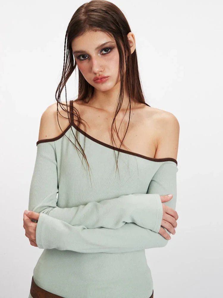 Detailed shot of the light green ribbed knit one-shoulder top worn by a model.