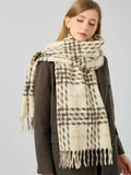 Close-up of a woman's face with a cream and brown plaid scarf draped around her neck.