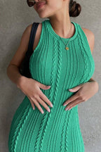 Close-up of a woman wearing a green cable knit dress showing intricate knit pattern