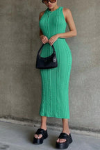 Woman wearing a bright green cable knit midi dress and black platform sandals