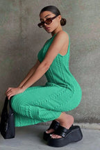 Woman in a green cable knit midi dress and platform sandals posing