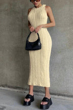 Woman wearing a cream cable knit midi dress and black platform sandals