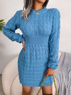 Woman wearing a blue cable knit long sleeve crew neck bodycon dress with a cinched waist.