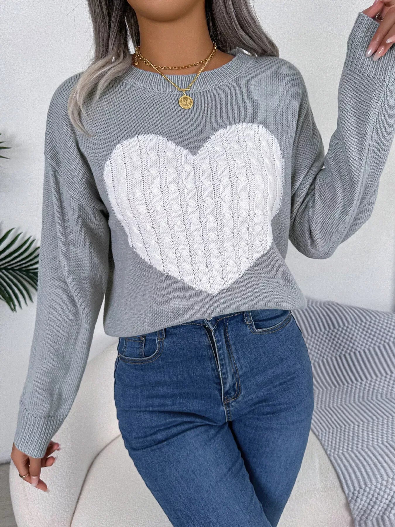Back view of a grey long sleeve knit sweater.