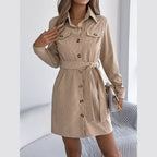 Woman wearing a beige corduroy shirt dress with a belted waist and button-down front.
