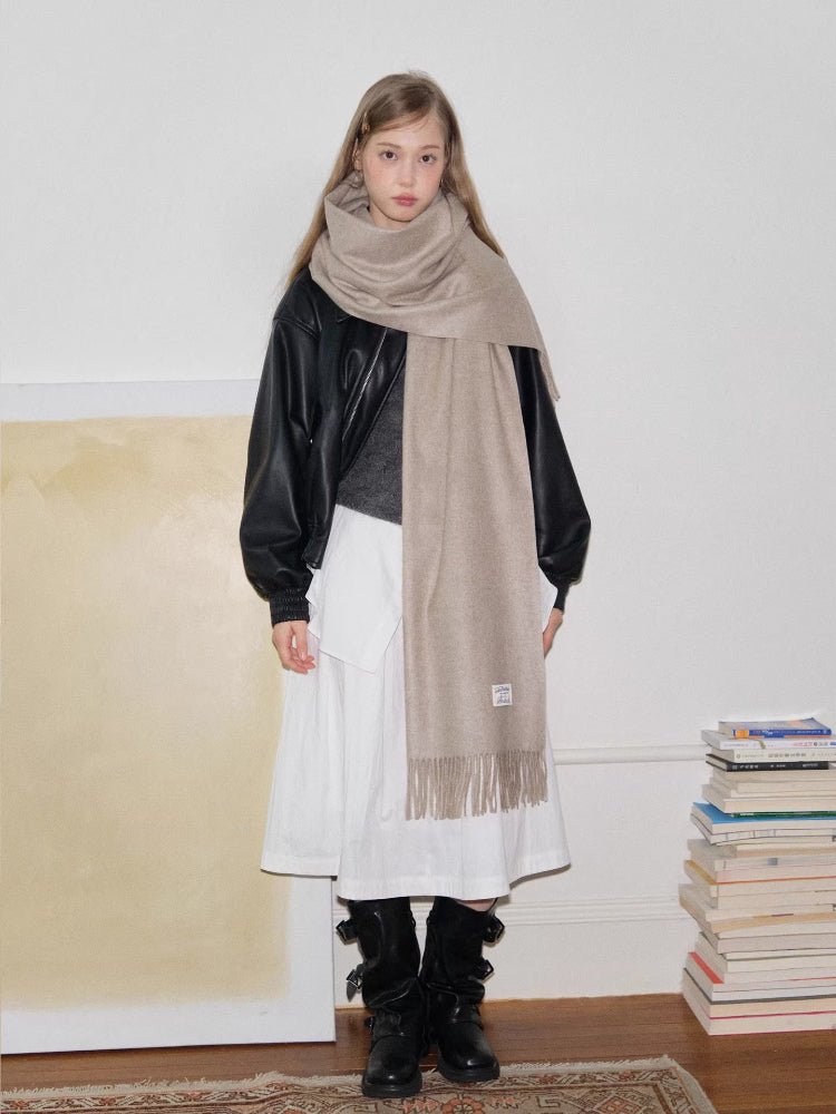 Full body shot of a woman wearing a beige scarf and winter attire.