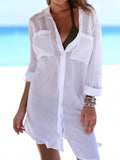 Woman wearing a white sheer crinkle cotton tunic over a bikini top on the beach