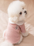 Back view of a white dog wearing a pink knit pet sweater with a white Peter Pan collar and a small embroidered bunny graphic on the back