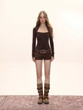 Full body shot of woman in long sleeve tie neck top and shorts