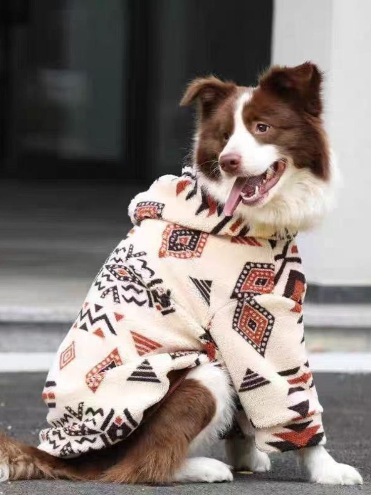 Side profile of a dog wearing a cream-colored fleece jacket with a geometric pattern.
