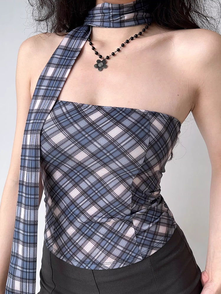 Close-up of a woman wearing a plaid tube top with an asymmetrical scarf detail.