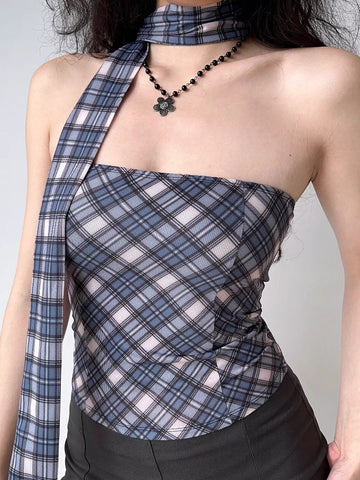 Close-up of a woman wearing a plaid tube top with an asymmetrical scarf detail.