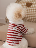 Rear view of a white dog wearing a red and white striped fleece sweater with a white collar, showing the 'Babby & Me' tag.
