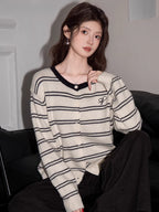Close-up of a woman's chest area, highlighting the striped pattern and button details of the knit cardigan.