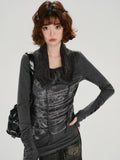 Front view of a woman wearing a dark gray long-sleeve top with a graphic print and a knit scarf collar.