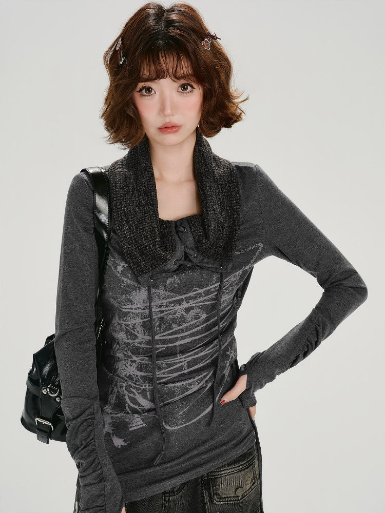 Front view of a woman wearing a dark gray long-sleeve top with a graphic print and a knit scarf collar.
