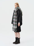 full body shot of woman in black jacket and oversized plaid scarf