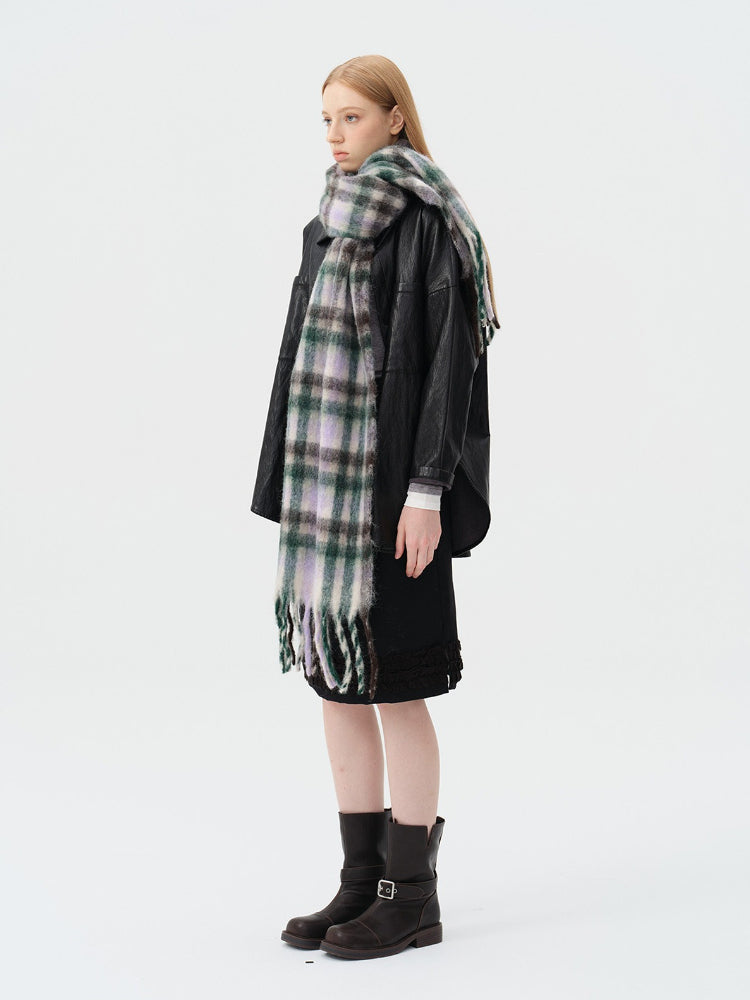 full body shot of woman in black jacket and oversized plaid scarf