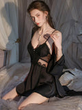 Woman posing in a black lace slip dress and robe set