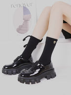 Fashionable black socks with unique bow embellishment.