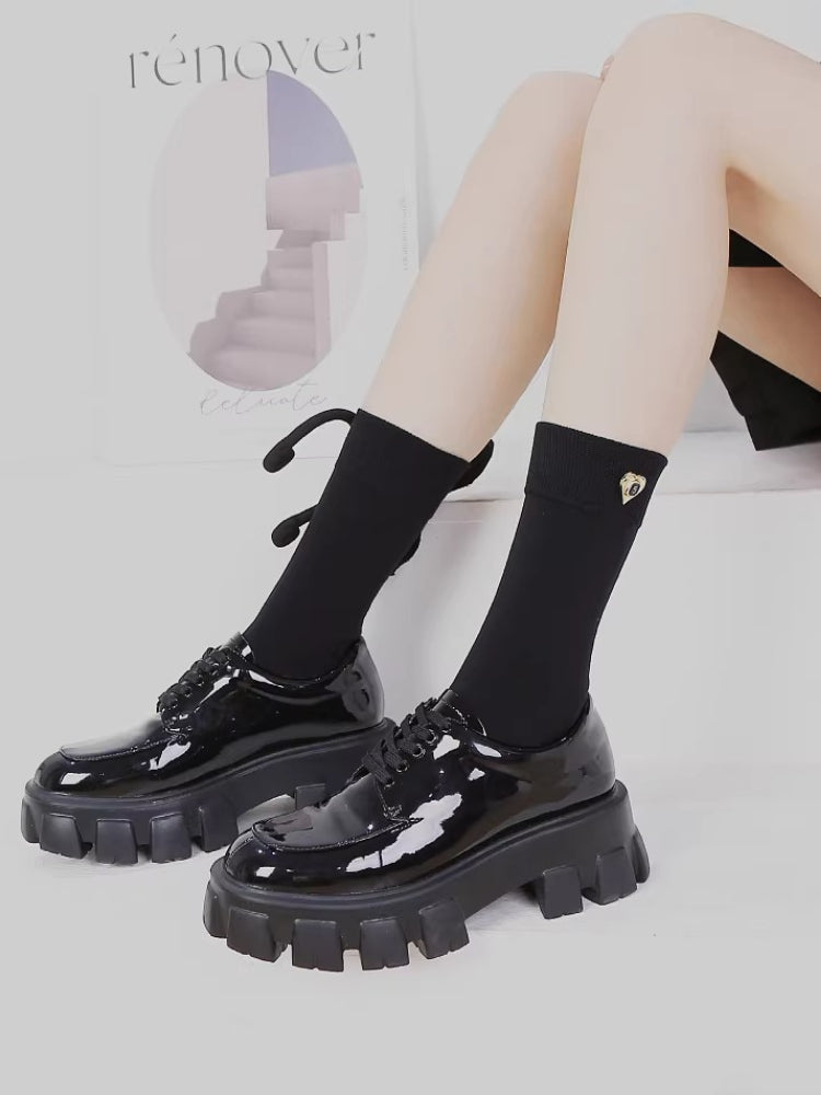 Fashionable black socks with unique bow embellishment.