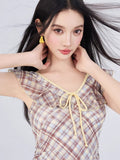 Close-up of the ruffled neckline and tie front detail on a plaid dress.